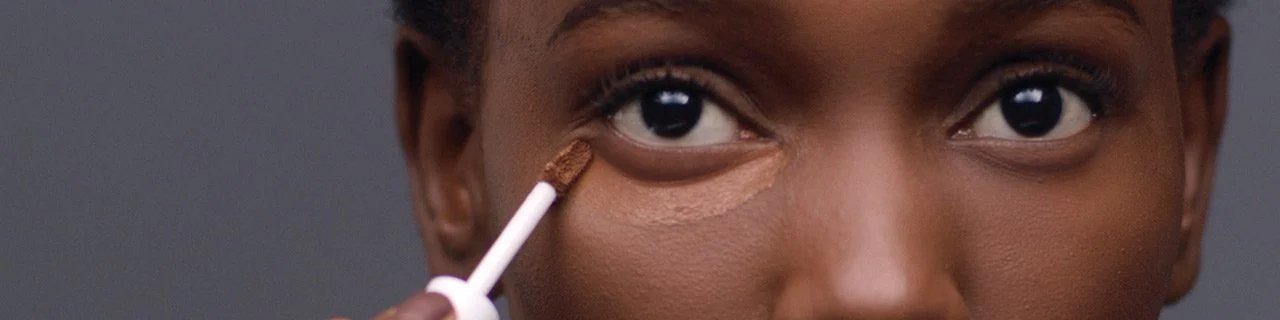 Concealer makeup tutorials illustrative banner image - close up of woman applying concealer under Eye